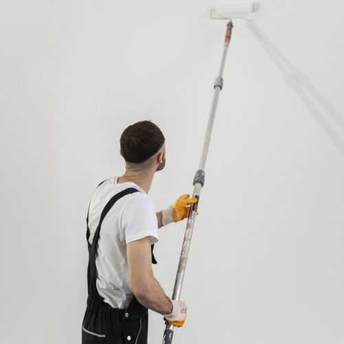 medium-shot-young-man-painting-wall medium-shot-young-man-painting-wall
